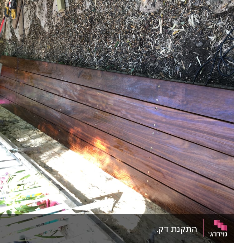 משטח עץ מלוטש עם ברגים בגינה